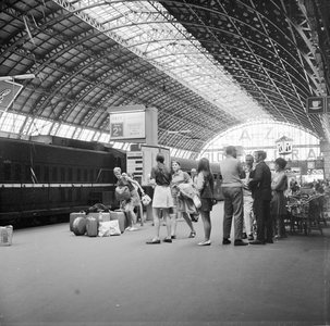 883103 Afbeelding van treinreizigers op het eerste perron van het N.S.-station Amsterdam C.S. te Amsterdam, tijdens het ...